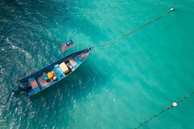 Bateau sans permis au mouillage dans le lagon guadeloupéen Petit bateau à moteur au mouillage sur le lagon turquoise du Grand Cul-de-Sac Marin